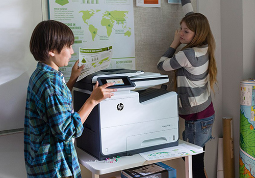 Boy and girl using HP printer in class