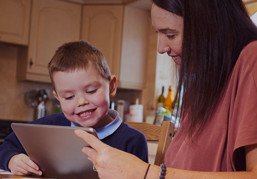 Young boy using device to learn from home