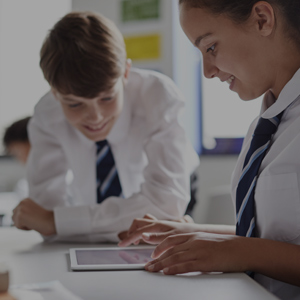 two student looking at a tablet device