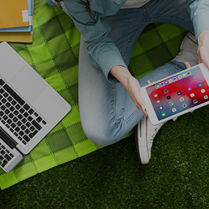 Female student using with both tablet and laptop devices